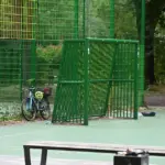 Leerer Bolzplatz mit grünem Fußballtor und abgestelltem Fahrrad