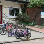 Kinderfahrräder vor dem Eingang einer Kita, daneben ein Banner zu Kinderrechten