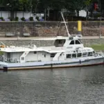Weißes Behördenboot der Bremischen Hafenvertretung liegt an der Weserpromenade