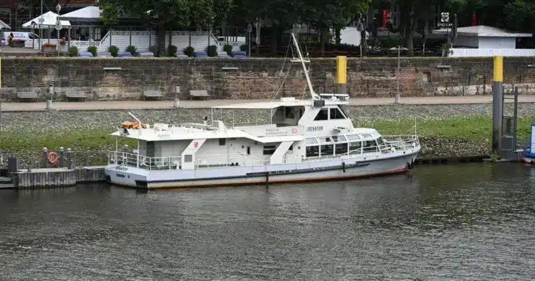 Weißes Behördenboot der Bremischen Hafenvertretung liegt an der Weserpromenade