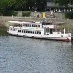 Weißes Ausflugsschiff liegt an der Weserpromenade