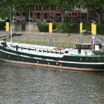 Dunkelgrünes Traditionsschiff liegt an der Weserpromenade vor Ort