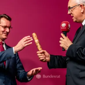 Zwei Männer in Anzügen überreichen sich gegenseitig einen ornaten Stab vor Bundesrat-Branding.